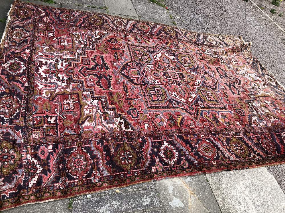 20TH CARPET WITH CENTRAL MEDALLION SUROUNDED BY GEOMETRIC PATTERNS ON A PREDOMINANTLY RED - Image 2 of 7