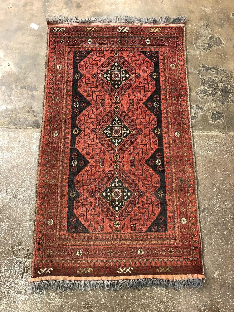 20TH CENTURY CARPET RUNNER WITH BLACK LOZENGE MOTIFS ON A RED BACKGROUND-FRINGED77CMX133CM