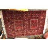 RED GROUND FRINGED CARPET WITH ALTERNATING MEDALLIONS 215 X 124CM APPROX