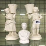 BELLEEK CREAM WARE BOY AND GIRL BASKET BEARER FIGURES AND A SMALL BUST OF QUEEN ELIZABETH II