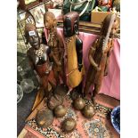FOUR CARVED AFRICAN MASAI FIGURES WITH SPEARS AND SHIELDS AND FOUR VINTAGE LAWN BOWLS