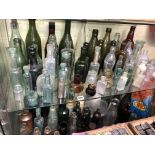 TWO SHELVES OF 19TH CENTURY GREEN AND COLOURED GLASS CHEMISTS BOTTLES,