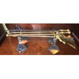 BRASS FIRE TOOLS ON BLACKENED ANDIRONS AND BRASS FINIAL FIRE CURB