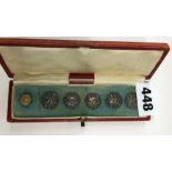 A CASE OF FIVE SILVER BUTTON (ONE MISSING)