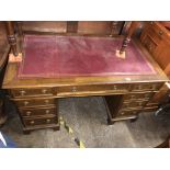 EDWARDIAN OAK NINE DRAWER KNEEHOLE DESK WITH RED GILT TOOLED SCIVER