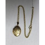 9CT GOLD OVAL ENGRAVED LOCKET ON A 9CT GOLD TRACE CHAIN 4.