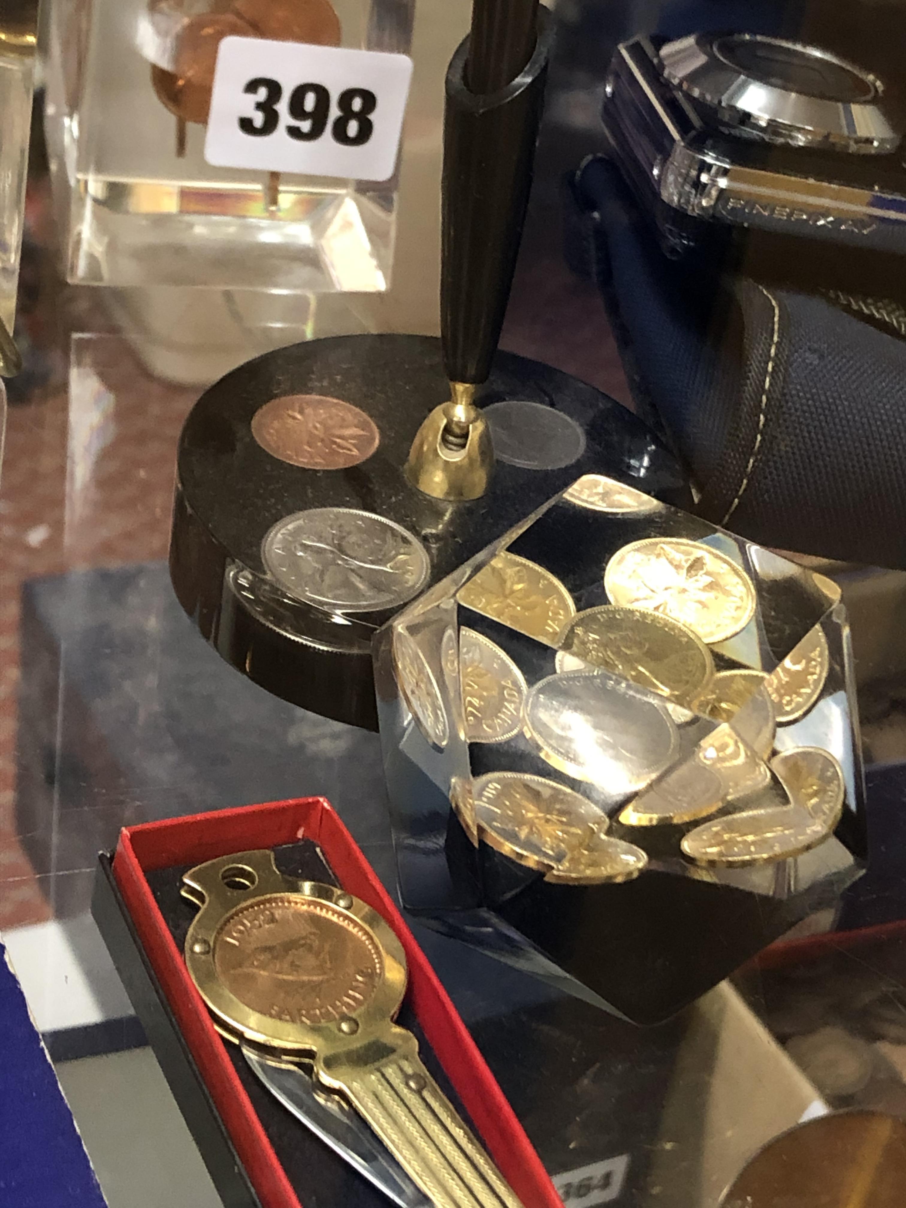 SELECTION OF NOVELTY COIN INSET PERSPEX PEG AND MONUMENT PAPERWEIGHTS AND A DESK STAND - Image 3 of 6