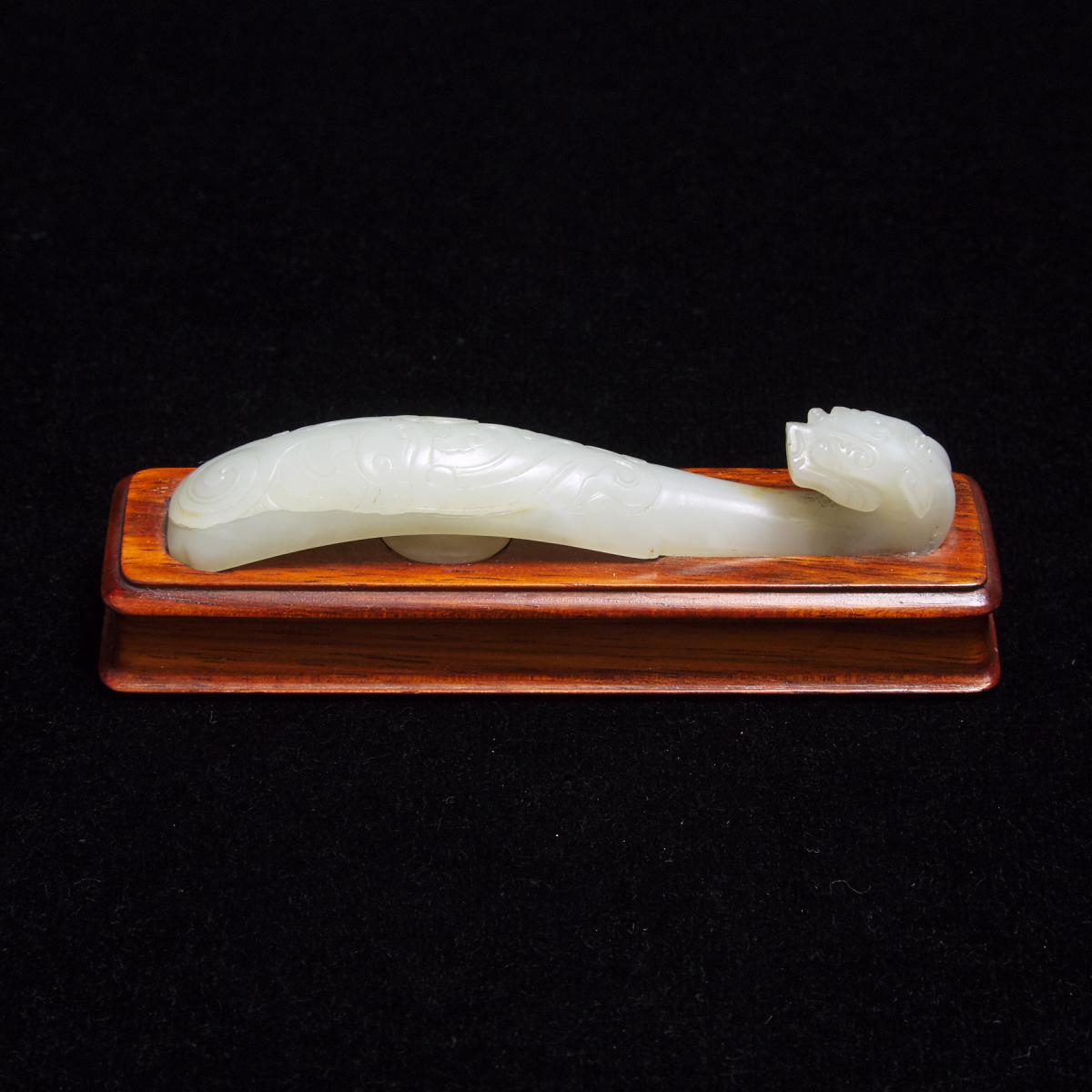 A White Jade 'Chilong' Belt Hook, Qing Dynasty, 清 白玉雕'苍龙教子'带钩, length 3.8 in — 9.7 cm