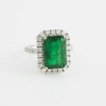 18k White Gold Ring, set with an emerald cut emerald (5.36ct.) encircled and flanked by 32 small bri