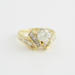 18k Yellow Gold Ring, set with a brilliant cut diamond (approx. 0.66ct.) and numerous baguette cut d