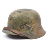 A Third Reich M42 steel helmet, with worn camouflage finish and Luftwaffe eagle decal, no visible