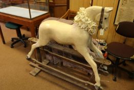 A traditional English produced children's hand carved wooden rocking horse. The horse is mounted