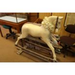 A traditional English produced children's hand carved wooden rocking horse. The horse is mounted