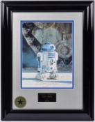 A Star Wars framed photograph of R2D2 with signed autograph by actor Kenny Baker. In gloss black