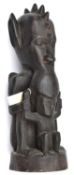 An African carved darkwood figure of a double deity, the top figure’s head with pointed ears and row