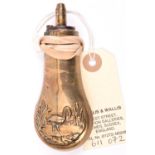 A copper pistol size powder flask, embossed with a stork standing in water with reeds, brass top