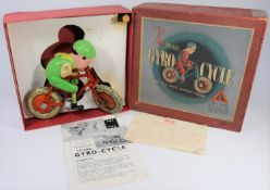 A Tri-ang (Lines Bros.) 1930s Gyrocycle. Green celluloid cyclist on a tinplate bicycle with