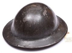 A WWI Brodie’s pattern steel helmet, dark green painted finish (some wear), with plain red oval