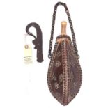 A 19th century Balkan brown leather covered powder flask, of triangular section tear drop form,