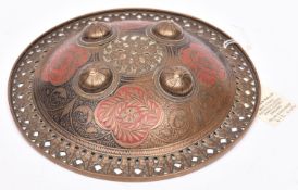 A small Benares circular brass shield dhal, pierced stylized foliate border and domed centre with