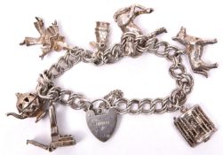 A silver coloured charm bracelet, double link chain, with tiny stage and 3 dancing girls with