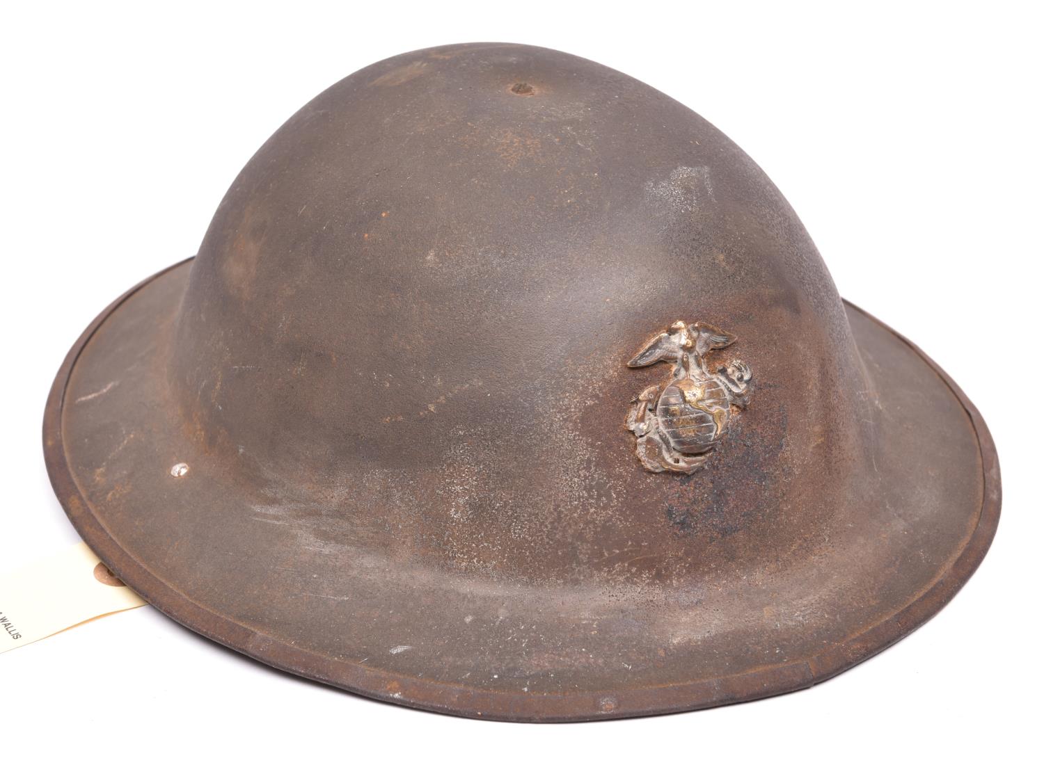 A WWI Brodie’s pattern steel helmet, with soldered on US Marine Corps badge, leather, netting and