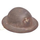 A WWI Brodie’s pattern steel helmet, with soldered on US Marine Corps badge, leather, netting and