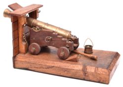 A model of an early 19th century ship’s cannon, brass barrel 6”, darkwood carriage, on a section