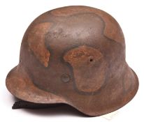 A Third Reich M42 steel helmet, with later WWI style camouflage finish and leather liner and