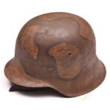 A Third Reich M42 steel helmet, with later WWI style camouflage finish and leather liner and