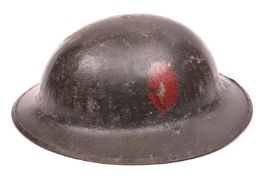 A WWI Brodie's pattern steel helmet, dark green painted finish (some wear), with plain red oval