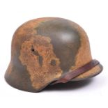 An M1936 Third Reich steel helmet, with original camouflage paint, leather lining and chinstrap.