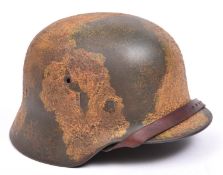 An M1936 Third Reich steel helmet, with original camouflage paint, leather lining and chinstrap.