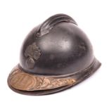 A WWI French Army Adrian steel helmet, grenade badge, and commemorative brass plate fixed to front