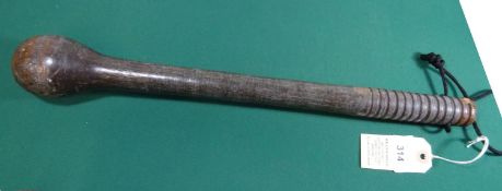 A hardwood club, 18" overall, with swollen head and ribbed handle, and with traces of grey/green