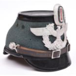 A Third Reich fibre Police shako, with aluminium badge and cockade, leather chinstrap, and maker’s