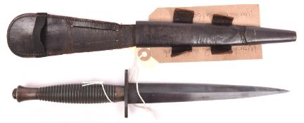 A WWII 3rd Pattern FS fighting knife, blued blade, ribbed hilt, in its scabbard, knife above average