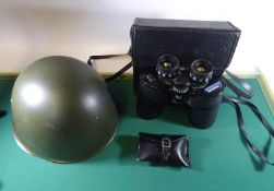 An East German military helmet, a Commodore 12x50 binocular in case; also a rifle cleaning kit in