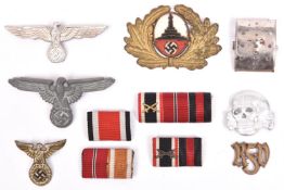 A Third Reich SS grey metal cap eagle; an SS death’s head with RZM mark; 2 other metal cap eagles; a