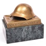 A Swiss Army brass paperweight, with marble base, depicting a helmet and bayonet. GC £50-60.