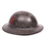 A WWI Brodie’s pattern steel helmet, dark green painted finish (some wear), with plain red oval