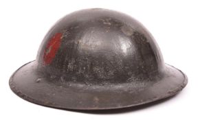 A WWI Brodie’s pattern steel helmet, dark green painted finish (some wear), with plain red oval
