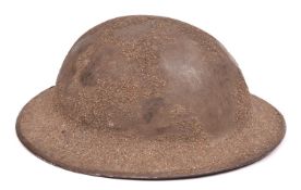 A WWI Brodie’s pattern steel helmet, rough sanded finish, leather chinstrap with owner’s no and