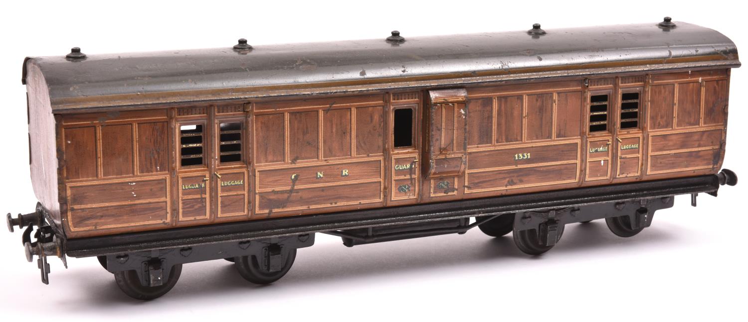 A Carette Gauge One non-corridor bogie guards van. A G.N.R. example in lined teak effect livery,