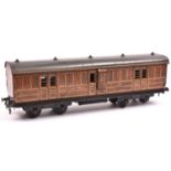 A Carette Gauge One non-corridor bogie guards van. A G.N.R. example in lined teak effect livery,
