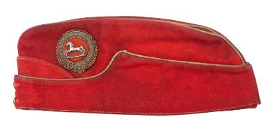 An Officer’s scarlet field cap of the 4th Hussars, gilt embroidered Garter badge with plated horse