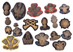 Bullion embroidered badges: RA Officer’s field cap badge, 3 P.O.W. feather badges probably from