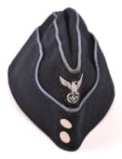 A Third Reich dark blue side cap, with small woven silver eagle, beaded silver buttons, and light