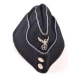 A Third Reich dark blue side cap, with small woven silver eagle, beaded silver buttons, and light