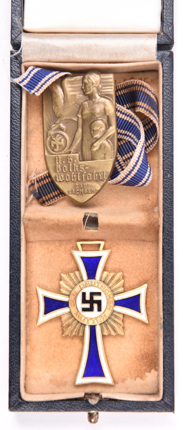 A Third Reich Mothers Cross, in its case, together with a “N S Volks Wohlfahrt” badge. GC £30-50